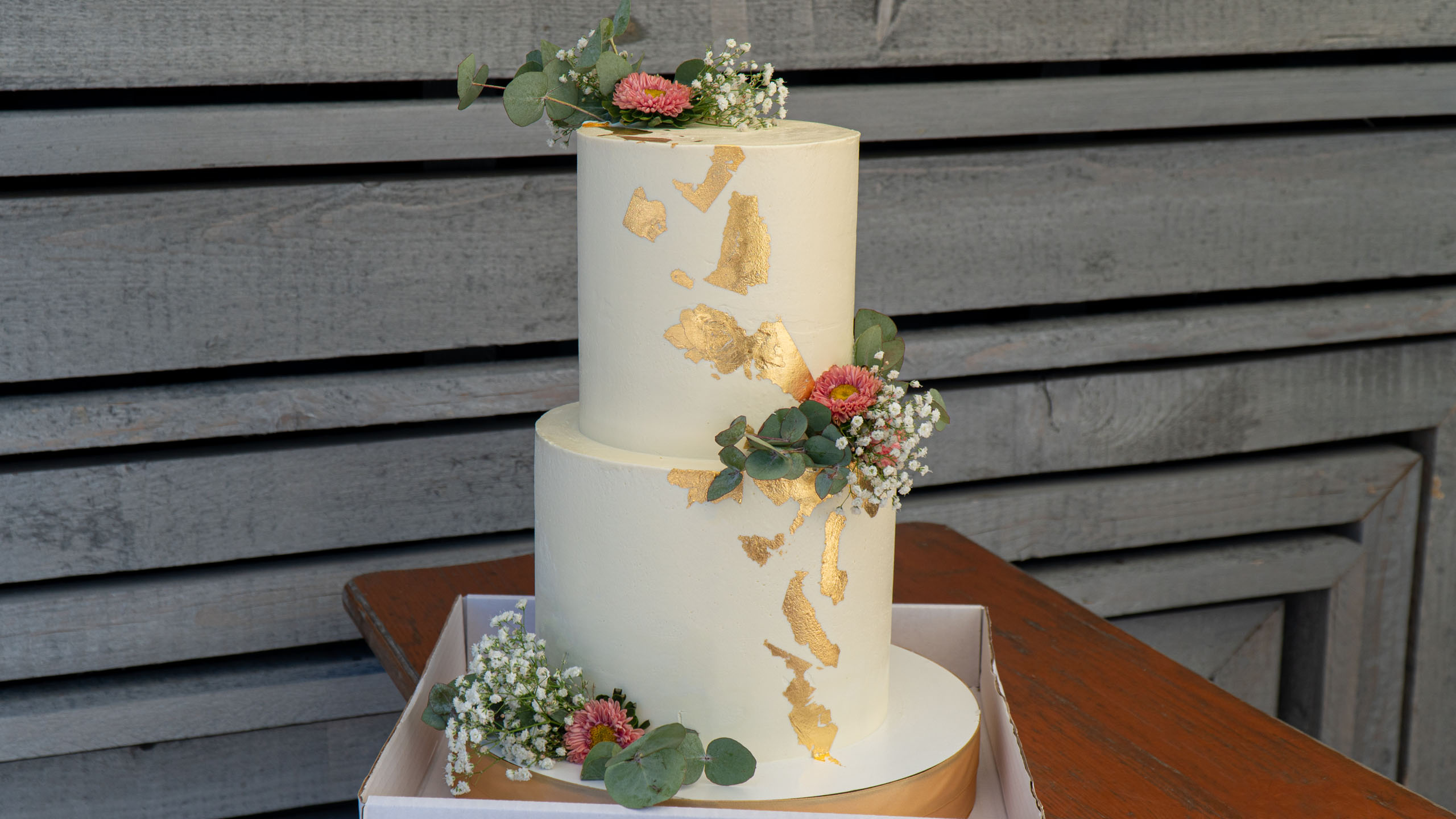Dvoupatrový svatební dort s květinami a zlatem